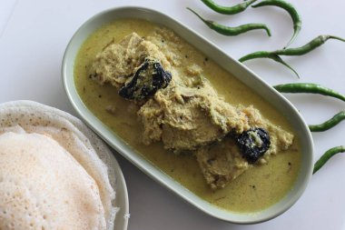 Kerala usulü, hindistan cevizi bazlı körili balık. Pirinç zıpzıp ile servis ediliyor. Kerala 'da genellikle Appam ve balık körisi denir. Beyaz arkaplanda sarı renkli körili balık.