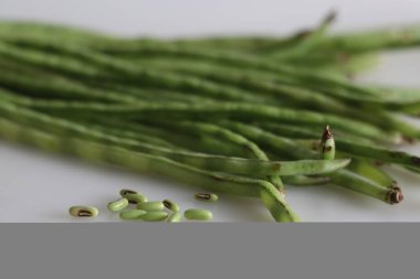 Bir sürü uzun fasulye. Ayrıca uzun ömürlü inek bezelyesi, kuşkonmaz fasulyesi, yılan fasulyesi ya da Çin uzun fasulyesi olarak da bilinir. Beyaz arkaplanda çekilen