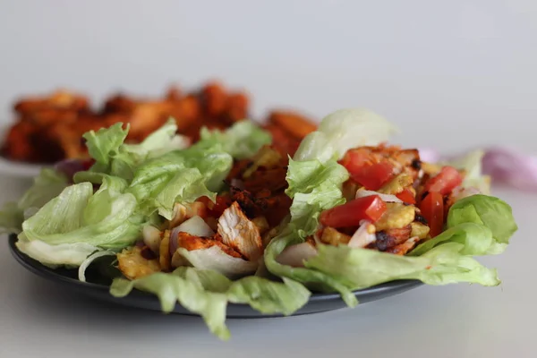Lettuce chicken wrap. Tandoori chicken bites, sauteed baby corn, fresh cut tomatoes and onions tossed and wrapped in iceberg lettuce leaves. Shot on white background