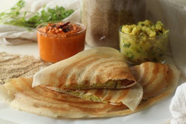 Mayalanmış darı ve mercimek hamurundan yapılmış çıtır krep. Ortasında patates püresiyle servis edilmiş. Yaygın olarak darı masala dosa olarak bilinir. Baharatlı domates sosuyla birlikte.