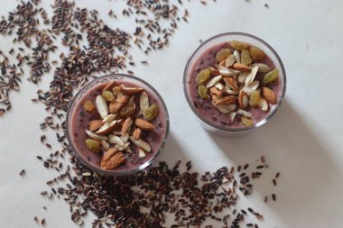 Siyah sütlaç. Süt ile kaynatılmış siyah pirinç, şekerle tatlandırılmış ve kakule tatlandırılmış. Pirinç yemek pişirirken mora döner. En besleyici olanıdır. Beyaz arkaplanda çekilen