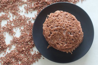 Kırmızı pirinç gözlemesi. Kırmızı pirinç ve hindistan cevizinden mayalanmış krep. Kerala 'da Red rice appam olarak da bilinir. Kerala 'nın favori kahvaltısının farklı bir versiyonu. Beyaz arkaplanda çekilen