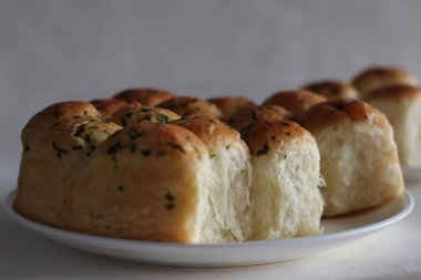 Yemek ruloları. Ev yapımı altın sarısı yemek ruloları fırından yeni çıkmış, tereyağlı ve dairesel pişirme tenekesi içinde. Beyaz arkaplanda çekilen