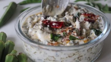 Cam kasede servis edilen süsleme yapan bayanlar parmak raita. Vendaka kichadi olarak da bilinir. Geleneksel Kerala yemekleri için yoğurt tabanlı bir meze. Kızarmış çıtır bayanlar parmaklarını kalın ve kremalı yoğurda sokuyorlar.