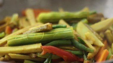 Popüler bir kerala yemeği olan Aviyal için yemek pişirirken tavada buğulanmış sebzeler. Yeşil biber, zerdeçal ve köri yapraklarıyla birlikte birçok sebzenin bir karışımıdır.