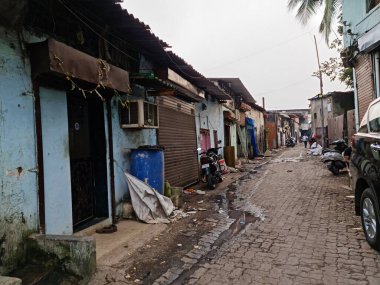 Mumbai, Maharashtra, Hindistan, 24 Şubat 2022: Mumbai, Kurla bölgesinden bir gecekondu mahallesine giden Nari Sewa Sadan Yolu 'nun dar bir yolu. Yan taraftaki dükkanlar ve evler.