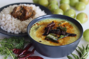 Nellika köri, Kerala pirinç yemeğiyle servis edilir. Kerala stili hindistan cevizi körisi, bektaşi üzümü, Hindistan cevizi ve baharattan yapılma. Beyaz arkaplanda çekilen.