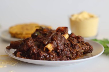 Makki ki roti ya da maize roti ile servis edilen koyun rostosu. Kerala usulü baharatlı koyun rostosu, mısır unundan yapılmış mayasız Hint ekmeğiyle servis edilir. Beyaz arkaplanda çekilen