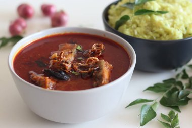 Kerala stiliyle hazırlanmış Hint tereyağlı balık körisi püre tapyoka ile servis edilir. Beyaz arkaplanda çekilen