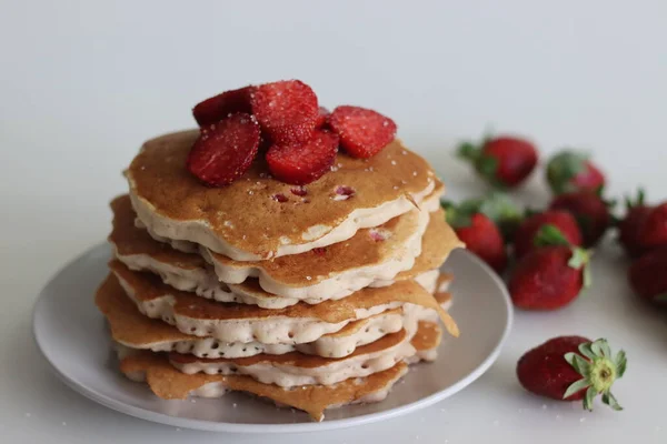 Strawberry pancakes. Soft and fluffy Buttermilk pancakes with fresh strawberries made with fresh cut strawberries added to the batter made of flour, buttermilk and eggs. Shot on white background