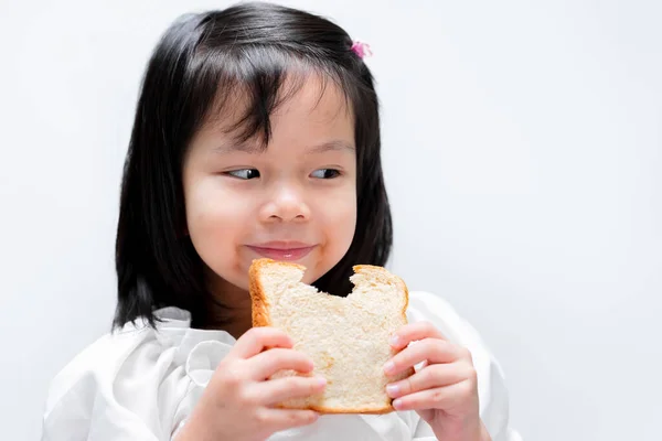 幸せな美しい女の子のスライスパンを食べる 子供たちは朝食で食べる — ストック写真