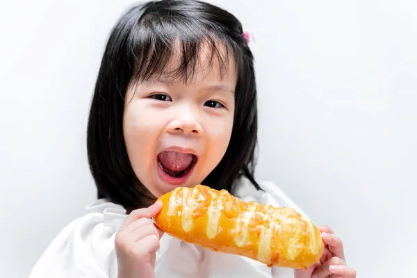 面白い女の子甘いジャムでおいしいパンを食べています 子供はカメラを見ている 隔離された白い背景で — ストック写真