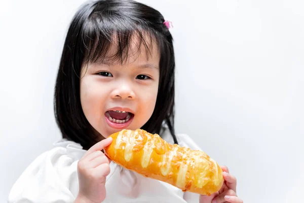 幸せな子供は甘い黄色のパンを食べる 子供のためにスナック 白い背景で 甘いです笑顔の女の子 — ストック写真