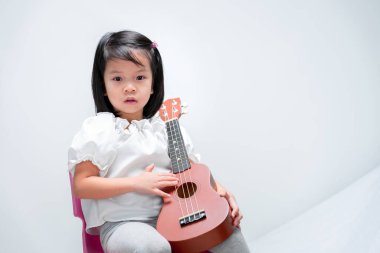 Çocuklar ukulele tutun. Müzik çalmaya çalıştı..