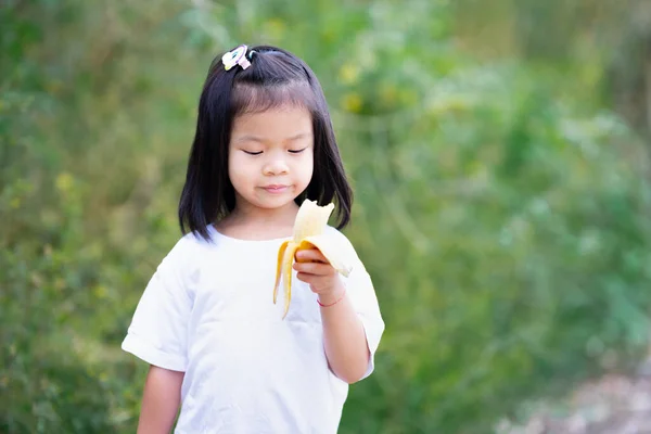 Χαριτωμένο Παιδί Κοιτάζει Ώριμη Μπανάνα Στα Χέρια Της Παιδί Κορίτσι — Φωτογραφία Αρχείου