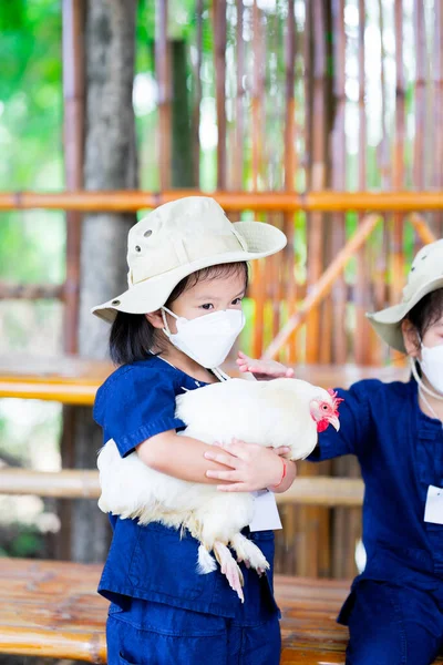 Παιδί Που Φοράει Λευκή Μάσκα Στέκεται Κρατώντας Μεγάλο Κοτόπουλο Παιδιά — Φωτογραφία Αρχείου