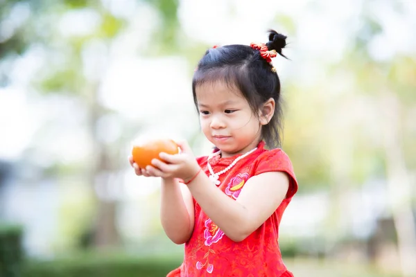 オレンジの果実を持つ可愛いアジアの子供の女の子 中国の旧正月のコンセプト 子供は赤いQipao Chengsamを身に着けている 子供は4歳 — ストック写真