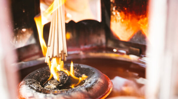 Incense sticks that are lit at end. For praying for gods. Empty space entering text. Concept belief and faith.