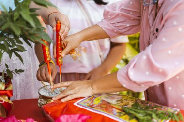 Kamphaeng Phet Thailand-14 Ocak 2022: Ailenin elleri, gelinin damat evine düğün törenine hazırlanmak için çanaklara uğurlu kırmızı mumlar koymaya yardım ediyor. Yurtdışı Çin gelenekleri.