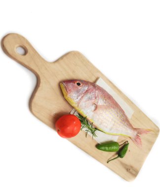 Taze Pembe Tünek (iplik yüzgeçli Bream) ahşap bir ped üzerinde sebzelerle süslenmiş, Beyaz Arkaplan, Seçici odak.