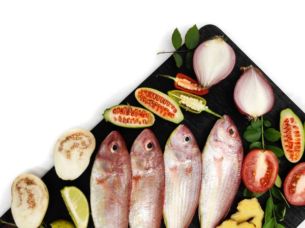 Taze Pembe Tünek (iplik yüzgeçli Bream) ahşap bir ped üzerinde sebzelerle süslenmiş, Beyaz Arkaplan, Seçici odak.