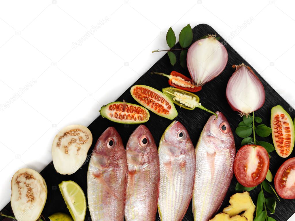 Fresh Pink Perch (thread finned Bream) Decorated with vegetables on a wooden pad,White Background,Selective focus.