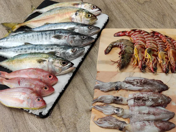 Tahta bir Pad.fish online pazarlama kavramı üzerine dekore edilmiş çeşitli balıkların seçici odağı.