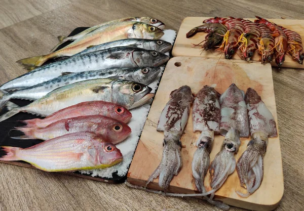 Tahta bir Pad.fish online pazarlama kavramı üzerine dekore edilmiş çeşitli balıkların seçici odağı.