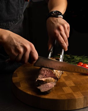 Şef tahtada biftek doğruyor.