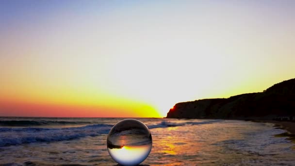 Szklana Kula Stoi Klifie Przed Morzem Falami Świetlnymi Zachodzie Słońca — Wideo stockowe