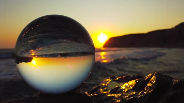 Uma Bola Vidro Está Penhasco Frente Mar Por Sol Quando — Vídeo de Stock