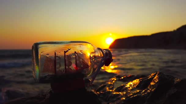Een Schip Een Fles Bij Zonsondergang Tegenover Een Kalme Zee — Stockvideo