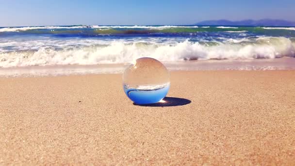 柔和的海浪缓缓地在海面上的沙地上冲刷着玻璃球 — 图库视频影像