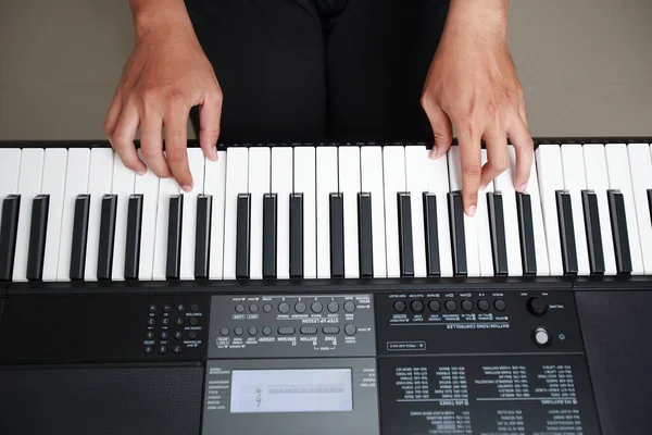 Asian man playing piano at home