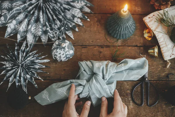 Manos Sosteniendo Regalo Navidad Envueltas Tela Sobre Mesa Madera Rústica — Foto de Stock