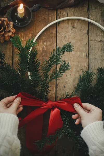 손으로 크리스마스의 화환을 만들고 전나무 가지와 리본으로 소나무 대기의 이미지 — 스톡 사진