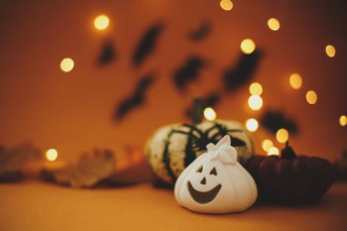 Mutlu Cadılar Bayramı. Balkabağı, balkabağı, balkabağı feneri, mum, koyu turuncu arka planda uçan siyah yarasalı örümcek. Atmosferik Cadılar Bayramı geçmişi. Tebrik kartı, metin için boşluk