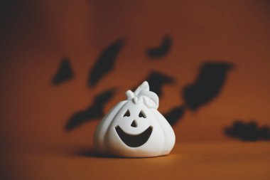 Cadılar Bayramı geçmişi. Koyu turuncu arka planda uçan siyah yarasalarla balkabağı süslemesi. Mutlu Cadılar Bayramı. Mesaj için yeri olan tebrik kartı. Şaka mı şeker mi?