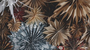 Noel afişi. Şık Noel yıldızları kırsal arka planda yatıyordu. Noel ambalaj kağıdından yapılmış güzel kağıt yıldızları. İskandinav modern dekoru. Kış tatili