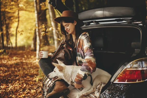 Stylová Hipster Žena Šálkem Batohem Sedí Roztomilým Psem Kufru Auta — Stock fotografie