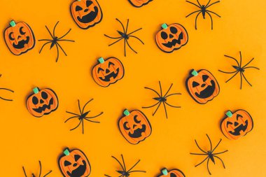 Cadılar Bayramı yatıyordu. Modern balkabakları Jack o Lantern ve turuncu arka planda örümcekler. Mutlu Cadılar Bayramı. Sarı kağıttaki Cadılar Bayramı süslemeleri. Cadılar Bayramı geçmişi