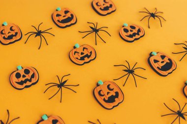 Mutlu Cadılar Bayramı. Balkabağı Jack o fener ve turuncu arka planda örümcekler. Sarı kağıtta cadılar bayramı süslemeleri. Cadılar Bayramı geçmişi. Şenlik deseni