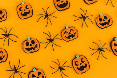 Cadılar Bayramı yatıyordu. Modern balkabakları Jack o Lantern ve turuncu arka planda örümcekler. Mutlu Cadılar Bayramı. Sarı kağıttaki Cadılar Bayramı süslemeleri. Cadılar Bayramı geçmişi