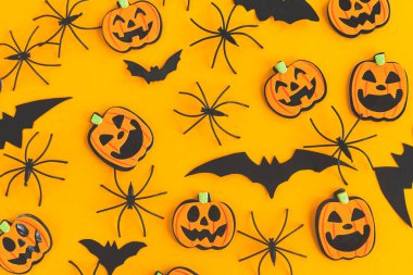 Cadılar Bayramı geçmişi. Modern balkabakları Jack o Lantern, örümcekler, turuncu arka planda yarasa yerleşimi. Cadılar Bayramınız kutlu olsun. Sarı kağıtta Cadılar Bayramı süslemeleri