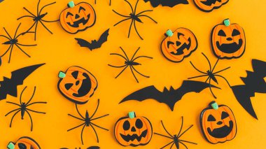 Cadılar Bayramı afişi düzdü. Modern balkabakları Jack o Lantern, örümcekler, turuncu arka planda yarasa yerleşimi. Mutlu Cadılar Bayramı. Sarı kağıttaki Cadılar Bayramı süslemeleri. Cadılar Bayramı geçmişi