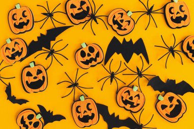 Cadılar Bayramı yatıyordu. Modern balkabakları Jack o Lantern, örümcekler, turuncu arka planda yarasa yerleşimi. Mutlu Cadılar Bayramı. Sarı kağıttaki Cadılar Bayramı süslemeleri. Cadılar Bayramı geçmişi