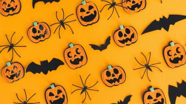 Cadılar Bayramı afişi düzdü. Modern balkabakları Jack o Lantern, örümcekler, turuncu arka planda yarasa yerleşimi. Mutlu Cadılar Bayramı. Sarı kağıtta Cadılar Bayramı süslemeleri