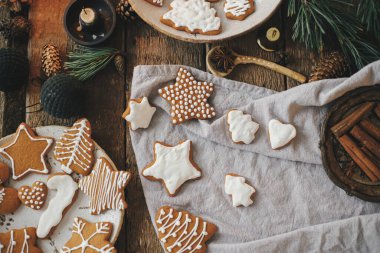 Noel kurabiyeleri peçete, mum, dekorasyon ve baharatlı köy ekmeği masasında. Düz yatıyordu. Atmosferik karamsar görüntü. Güzel dekore edilmiş zencefilli kurabiye. İyi tatiller.!