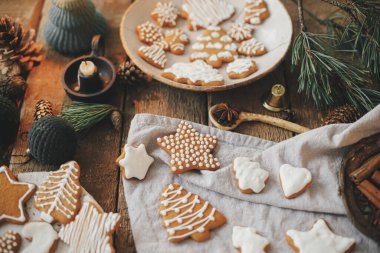 Noel kurabiyeleri peçete, mum, dekorasyon ve baharatlı köy ekmeği masasında. Atmosferik karamsar görüntü. Güzel dekore edilmiş zencefilli kurabiye. Mutlu Noeller ve mutlu tatiller!