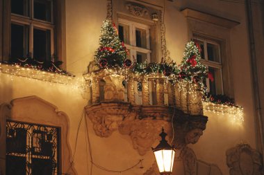 Şık noel ağaçları, dallar, kırmızı süsler gece vakti binanın balkonundaki aydınlatma ışıkları. Atmosferik sihir zamanı. Kış tatilleri için Noel dekorasyonu. Mutlu Noeller.!